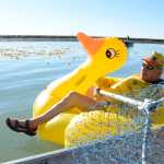 Photo by Megan Pacer/Peninsula Clarion Kenai Lions Club secretary and treasurer Dennis Swarner prepares to climb aboard a boat collecting hundreds of rubber ducks on the Kenai River during the organization's 20th Rubber Ducky Race fundraiser Saturday, Sept. 10, 2016 at Cunningham Park in Kenai, Alaska. This is the largest general fundraiser for the Kenai Lions Club, which is celebrating its 50th anniversary.