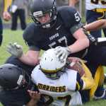 Photo by Joey Klecka/Peninsula Clarion Nikiski lineman Tyler Litke (57) stuffs Homer running back Noah Fisk Saturday at Nikiski HIgh School.