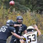 Photo by Joey Klecka/Peninsula Clarion Nikiski Bulldogs quarterback Ian Johnson (8) lobs up a pass with Homer linebacker Seth Classen (53) closing in during the first half against Homer Saturday at Nikiski High School.
