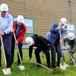 Photo by Elizabeth Earl/Peninsula Clarion Alaska Christian College President Dr. Keith Hamilton (center) bends down to get extra leverage during a groundbreaking ceremony for the new Taikuu dormitory at the college's 15th anniversary celebration Friday, Sept. 16, 2016 near Soldotna, Alaska. The two-year Bible college serves Alaska Natives and this year has 10 students from the Navajo nation in Arizona.