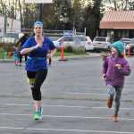 Photo by Elizabeth Earl/Peninsula Clarion Ava Fabian, 10, of Seward, cheers on her mom Jenna Fabian as she finishes a half-marathon run at the Kenai River Marathon on Sunday, Sept. 25, 2016 in Kenai, Alaska.