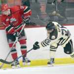 Photo by Jeff Helminiak/Peninsula Clarion New Jersey Titans forward Jordan Kaplan protects the puck from Brown Bears forward Jonathan Marzec on Friday at the Soldotna Regional Sports Complex.