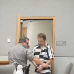 Homer Police Department Community Jail Officer Rick Pitta brings John Suter into the Homer District Courthouse for s his arraignment on Friday morning, Oct. 7.