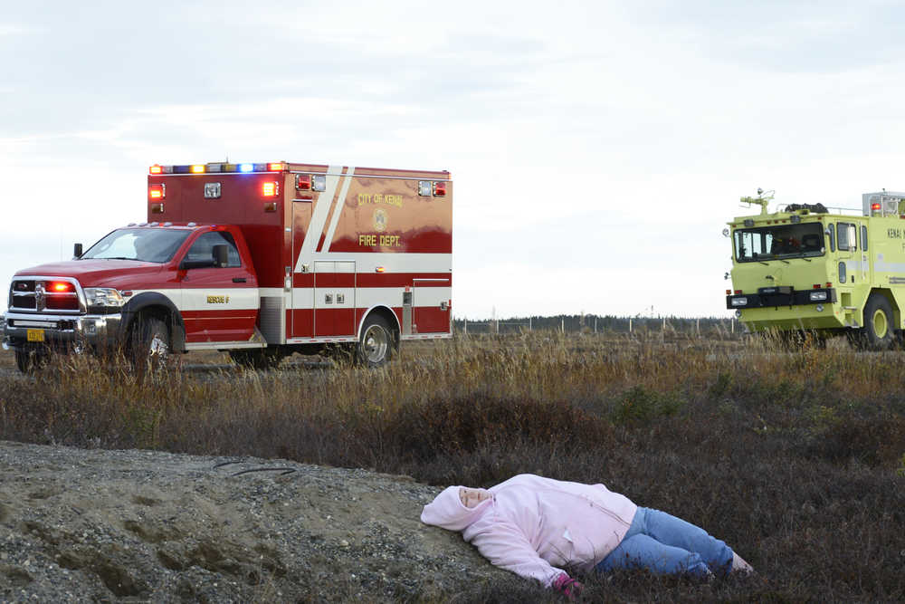 Photo by Megan Pacer/Peninsula Clarion Kenai Firefighter Ben Nabinger sprays foam onto the site of a simulated plane crash during a mass casualty drill Tuesday, Oct. 11, 2016 at the Kenai Municipal Airport in Kenai, Alaska. The airport is required by the Federal Aviation Administration to hold the drill every three years to test its emergency planning.