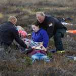 Photo by Megan Pacer/Peninsula Clarion A firefighter bends down to check the tag of a volunteer victim to see if he is hurt or dead during a mass casualty drill Tuesday, Oct. 11, 2016 at the Kenai Municipal Airport in Kenai, Alaska. The airport is required by the Federal Aviation Administration to hold the drill every three years to test its emergency planning.