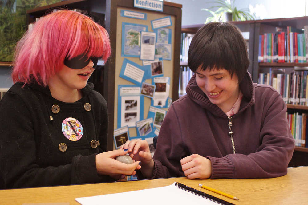 Ben Boettger/Peninsula Clarion Blindfolded River City Academy student Amelia Johnson feels the shape of a stone egg, presented to her by fellow student Maria Maes, during River City's Blindness Challenge on Thursday, Oct. 13 in Soldotna. Maes, a blind student, helped organize a series of events that allowed blinfolded students to experience the world tactilely and to use the tools blind people use for drawing, writing, typing, and other tasks.