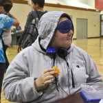 Ben Boettger/Peninsula Clarion Calysa Saporito-Mills eats lunch blindfolded in the River City Academy gym/cafeteria during the Blindness Challenge on Thursday, Oct. 13 in Soldotna.