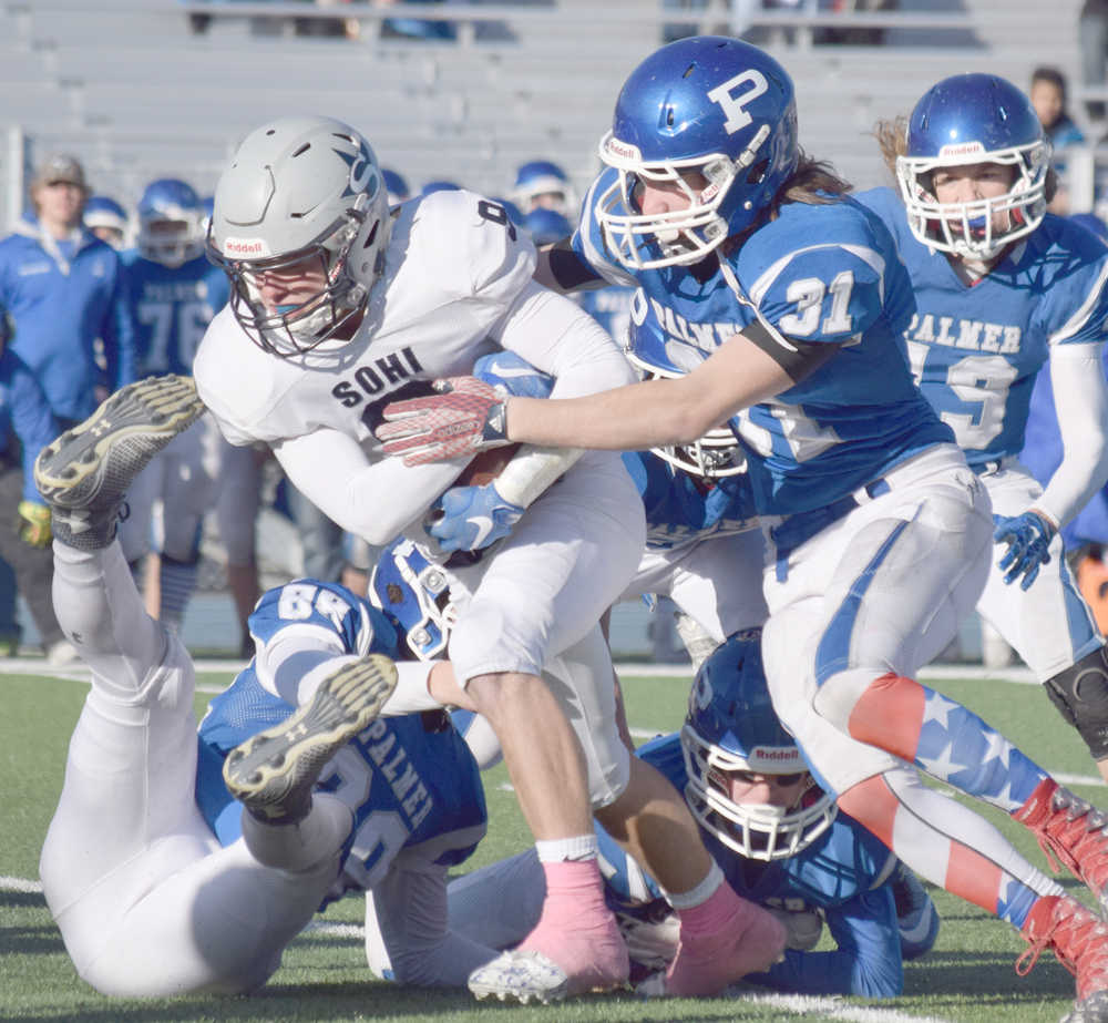 Photo by Joey Klecka/Peninsula Clarion Soldotna running back Jace Urban tries to shed a tackle by Palmer's Jacoby Glenn (31) Saturday in the medium-schools state championship game at Palmer High School.
