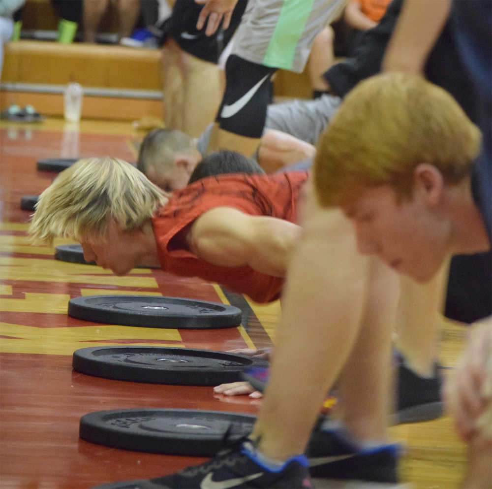 Photo by Joey Klecka/Peninsula Clarion Kenai Central sophomore Jarrett Wilson (in red) works hard among a line of boys competing in the Fight Gone Bad competition Wednesday night at Kenai Central High School.