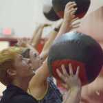 Photo by Joey Klecka/Peninsula Clarion Nikiski sophomore Jace Kornstad (foreground) and Soldotna sophomore Braxton Urban compete in the Fight Gone Bad competition Wednesday evening at Kenai Central High School.