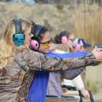 Photo by Megan Pacer/Peninsula Clarion Elaina Spraker lends a helping hand to Ava Gabler, 17, during a practice drill in the Teens on Target program Thursday, Oct. 20, 2016 at the Snowshoe Gun Club Range in Kenai, Alaska.