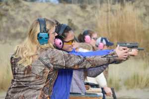 Photo by Megan Pacer/Peninsula Clarion Elaina Spraker lends a helping hand to Ava Gabler, 17, during a practice drill in the Teens on Target program Thursday, Oct. 20, 2016 at the Snowshoe Gun Club Range in Kenai, Alaska.