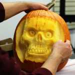 Photo by Ben Boettger/Peninsula Clarion Kenai Community Library children's librarian James Adcox examines a skull he's carved out of a pumpkin during a pumpkin-carving session on Tuesday Oct. 25 at the library in Kenai.