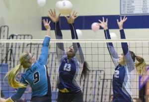 Photo by Joey Klecka/Peninsula Clarion Nikiski outside hitter Jamie Yerkes (9) is met by a fierce block by Soldotna's Ituau Tuisaula (13) and Drewe Zeek Saturday afternoon at Soldotna High School.