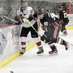 Photo by Jeff Helminiak/Peninsula Clarion Kenai Central's Matthew Zorbas and Houston's Ree Humphreys tangle along the boards Friday at the Soldotna Regional Sports Complex during the Peninsula Ice Challenge.
