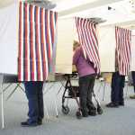 Photo by Megan Pacer/Peninsula Clarion Residents cast their votes behind red, white and blue veils Tuesday, Nov. 8, 2016 at the North Peninsula Recreation Center in Nikiski, Alaska.