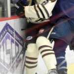 Photo by Jeff Helminiak/Peninsula Clarion Kenai River's Alex Dingeldein gets taken into the boards by Jack Gates of the Janesville (Wisconsin) Jets on Friday at the Soldotna Regional Sports Complex.
