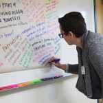 Photo by Megan Pacer/Peninsula Clarion Jessica Limbird, program associate for YWCA Alaska in Anchorage, adds to a poster filled with ideas and thoughts from female veterans during a facilitated conversation held Thursday, Nov. 17, 2016 at Peninsula Community Health Services in Soldotna, Alaska through the Alaska Veterans' Organization for Women program.