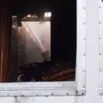 Photo by Megan Pacer/Peninsula Clarion A firefighter sprays foam onto the damaged areas of a mobile home that caught fire Tuesday, Nov. 22, 2016 on Blanch Street, off of Kalifornsky Beach Road, near Soldotna, Alaska. Firefighters were able to put out the blaze in the back bedroom and bathroom area of the mobile home within minutes and none of the occupants were hurt.