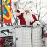 Photo by Megan Pacer/Peninsula Clarion Santa greets a crowd of excited families as he cruises into the Kenai Chamber of Commerce and Visitor Center parking lot on a Kenai Fire Deoartment engine Friday, Nov. 25, 2016 in Kenai, Alaska.