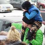 Photo by Megan Pacer/Peninsula Clarion Adam Meyers holds up his 4-year-old son, Bowe, and points in the direction Santa came from to greet families on his Kenai Fire Department engine during the annual Christmas Comes to Kenai celebration Thursday, Nov. 25, 2016 at the Kenai Chamber of Commerce and Visitor Center in Kenai, Alaska.