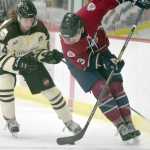Photo by Jeff Helminiak/Peninsula Clarion Anthony Tzveyn of the Brown Bears and Nolan Schaeffer of the Ice Dogs tangle for the puck Friday at the Soldotna Regional Sports Complex.
