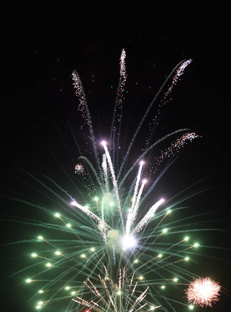 Photo by Megan Pacer/Peninsula Clarion Onlookers take in fireworks being set off above the Kenai Chamber of Commerce and Visitor Center during the finale of this yera's Christmas Comes to Kenai celebration Friday, Nov. 25, 2016 in Keneai, Alaska.