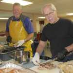 Mark Hutton and Dave Peterson carve numerous turkeys for the Salvation Army community dinner.