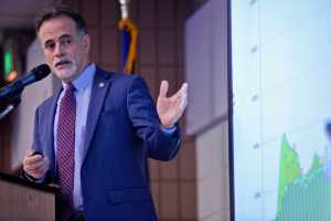Ben Boettger/Peninsula Clarion Senator Peter Micciche (R-Soldotna) gestures at a graph of state economic data while presenting to members of the Kenai and Soldotna Chambers of Commerce on Tuesday, Dec. 13 at the Soldotna Regional Sports Complex.