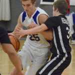 Photo by Joey Klecka/Peninsula Clarion Cook Inlet Academy senior Noah Leaf drives to the basket against Kodiak ESSS guard Ben Grossl, Thursday night at CIA.