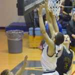 Photo by Jeff Helminiak/Peninsula Clarion Soldotna's Derek Evans challenges Ninilchik's Austin White at the rim Friday at Soldotna High School.