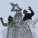 Jeremy Mann and Scott Morrison place the star atop the Soldotna Tree.