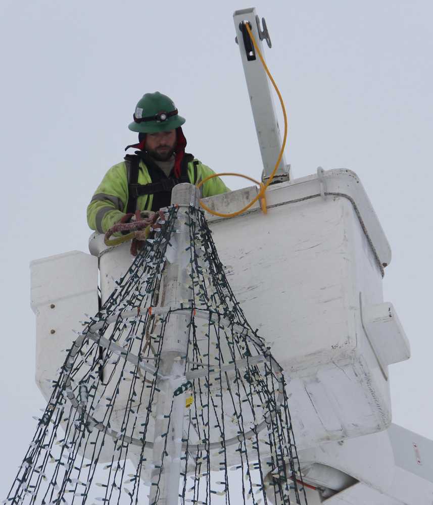 Jeremy Mann of HEA adjusts the Soldotna Creek Park tree.