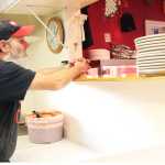 Photo by Megan Pacer/Peninsula Clarion The skeleton of a greenhouse stands in the snow Wednesday, Dec. 14, 2016 outside of Charlie's Pizza in Nikiski, Alaska. The restaurant's owner, Steve Chamberlain, will close shop on Jan. 1, 2017 and begin the transition to a new business, Everett's Acres Farm and Feed, that will sell a variety of animal feed and fresh produce grown by Chamberlain in an on-site greenhouse.