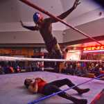 Photo by Ben Boettger/Peninsula Clarion Masked wrestler Phoenix Kid launches off the ropes at his grounded opponent, the Electric Redneck, during a pro-style wrestling match at the Fight Before Christmas martial arts event on Thursday, Dec. 22 in Soldotna's Peninsula Center Mall.