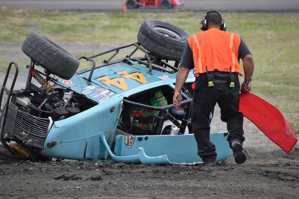 Photo by Joey Klecka/Peninsula Clarion A Twin City Raceway safety worker rushes to the aid of Legends driver Ty Torkelson, who went for a wild ride, July 23 at the track. Torkelson got out of his car and walked away.