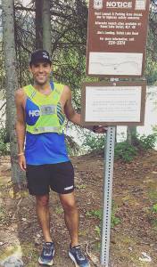 Pete Kostelnick stands next to a sign on Skilak Lake Road in a recent undated photo. (Photo provided by Pete Kostelnick)