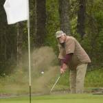 Jerry Norris lifts his ball out of a sand trap on hole No. 3 Sunday in the Kenai Open at the Kenai Golf Course. (Photo by Joey Klecka/Peninsula Clarion)