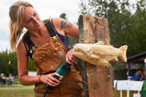 Sculptor Nichole Hoop works on a carving during the Alaska Wild Salmon Day festivities in Soldotna Creek Park on Friday in Soldotna. The event, organized by the conservation nonprofit Cook Inletkeeper, featured salmon-themed art, servings of salmon chowder, readings by fisher-poets, and music by Tyson James and Motown Fever. (Ben Boettger/Peninsula Clarion)