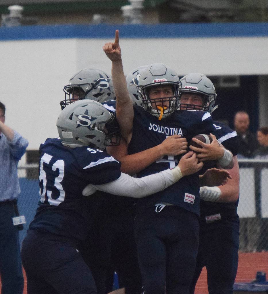 Soldotna junior Jersey Truesdell (pointing) is mobbed by teammates after scoring a touchdown Friday against West Anchorage at Justin Maile Field in Soldotna. (Photo by Joey Klecka/Peninsula Clarion)