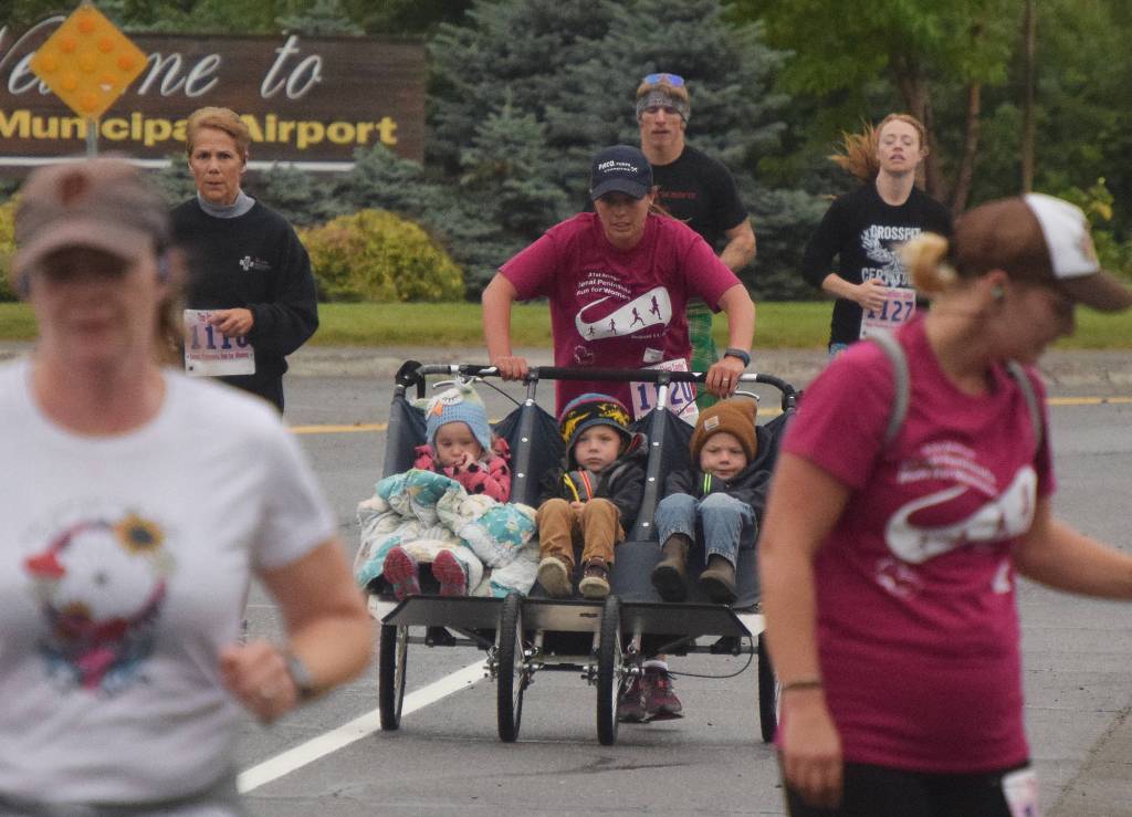 Lauren Pilatti pushes a stroller full of children Saturday morning in the 31st annual LeeShore Center Run for Women in Kenai. (Photo by Joey Klecka/Peninsula Clarion)