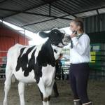 Elora Reichert displays the steer she raised during the auction at Kenai Peninsula Fair on Aug. 18, 2018 in Ninilchik, Alaska. (Photo by Elizabeth Earl/Peninsula Clarion)