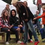 Sword swallower Dan Meyer presents a sword to audience member Cheyenne Juliussen, who pulled the sword out of his throat during Meyers last act, on Saturday, August 18, 2018 in Ninilchik, Alaska. (Photo courtesy Ben Boettger)