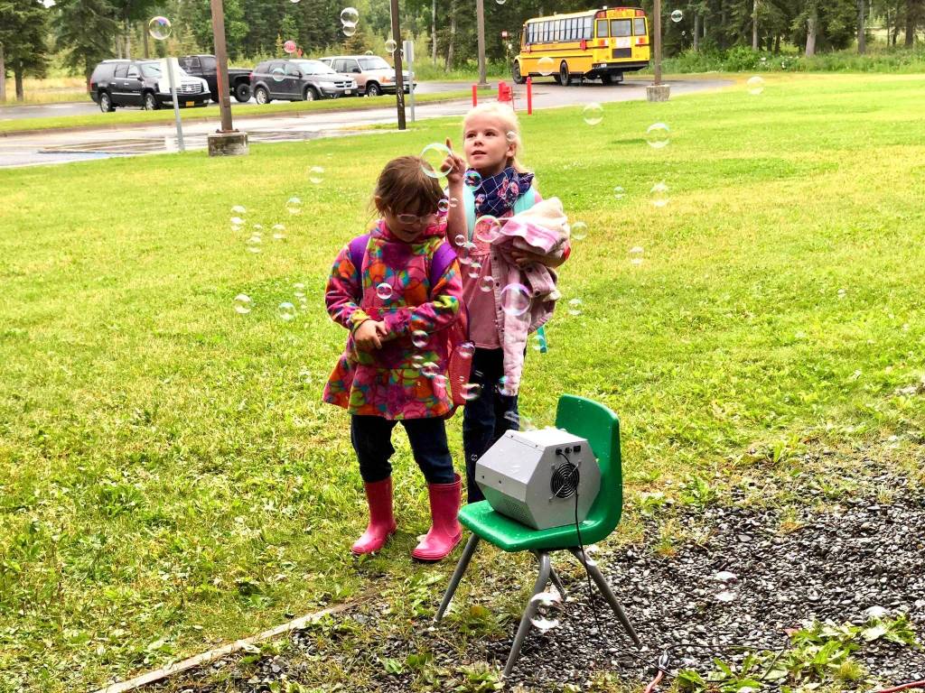 Two students play in the bubbles that greeted them on their first day of school on Tuesday, Aug. 21, 2018, at Mountain View Elementary in Kenai, Alaska. (Photo by Victoria Petersen/Peninsula Clarion)