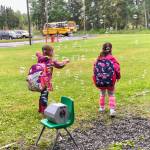 Two students play in the bubbles that greeted them on their first day of school on Tuesday, Aug. 21, 2018, at Mountain View Elementary in Kenai, Alaska. (Photo by Victoria Petersen/Peninsula Clarion)