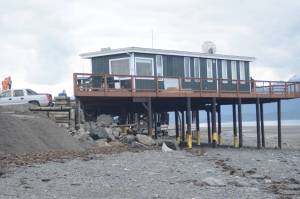 Fresh fill added on Aug. 15, 2018, replaces sand washed away last week after a series of storms and high tides eroded the beach near the Glacier Drive-In restaurant, shown here Aug. 16, 2018, on the Homer Spit, Alaska. Concrete armor rock holds the parking lot in place. The yellow plastic on the steel pilings shows where sand had been when they were installed several years ago. (Photo by Michael Armstrong/Homer News)