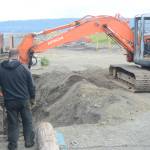 John Wise, left, and Nathan Wise, right, in backhoe, make repairs of the Glacier Drive-In on the Homer Spit, on Aug. 16, 2018, after a series of storms that eroded the beach last week during high tides in Homer, Alaska. (Photo by Michael Armstrong/Homer News)