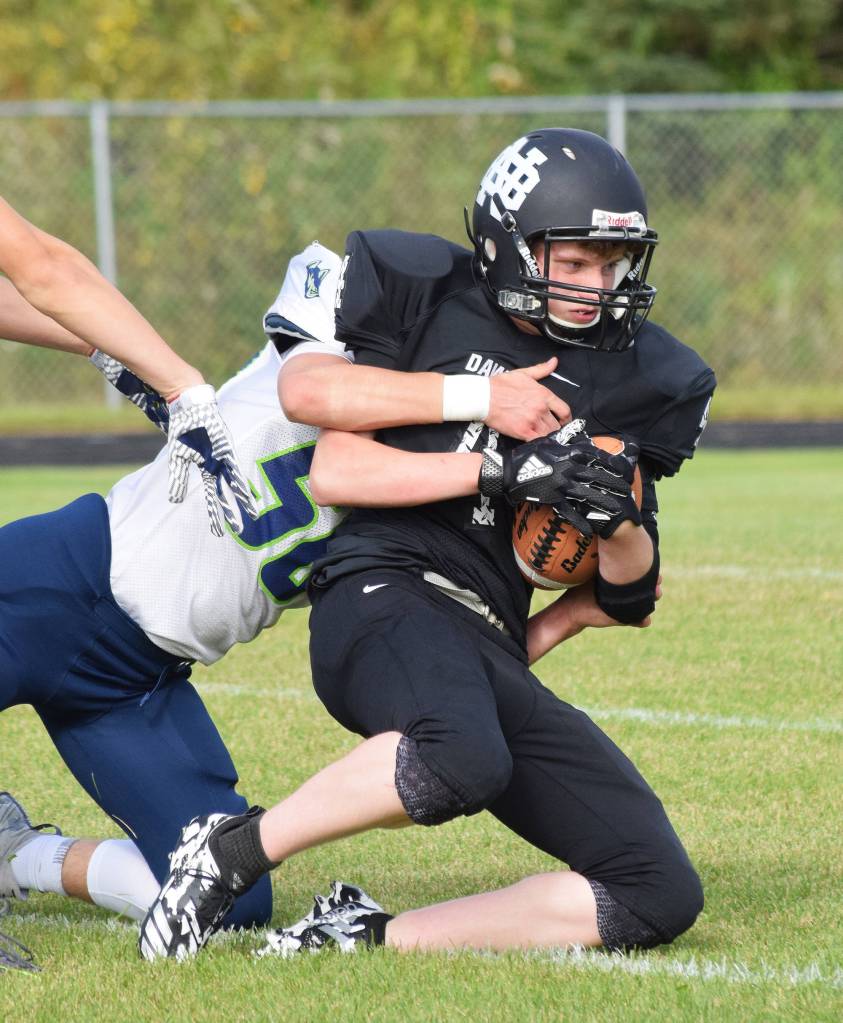 Nikiski sophomore Dylan Harris is tackled by Redingtons Eli Benson (50) Friday at Nikiski High School. (Photo by Joey Klecka/Peninsula Clarion)
