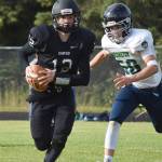 Nikiski quarterback Noah Litke evades a sack from Redingtons Eli Benson (50) Friday against the Redington Huskies at Nikiski High School. (Photo by Joey Klecka/Peninsula Clarion)
