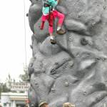 A young climber makes her way up a rock wall monitored by Alaska Army National Guard members at Industry Appreciation Day on Saturday, Aug. 25, 2018 in Kenai, Alaska. (Photo by Elizabeth Earl/Peninsula Clarion)